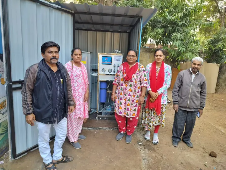 Community members beside a completed drinking-water system